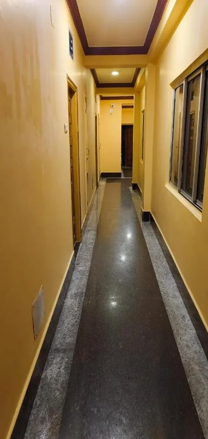 Granite-floored corridor with warm yellow walls at Hotel JM International