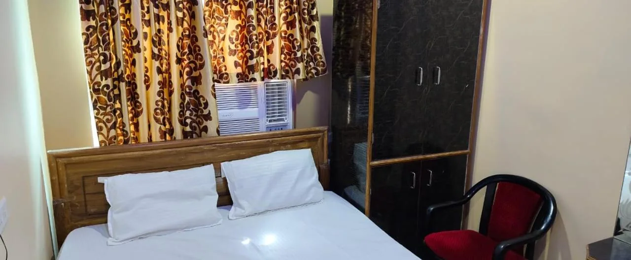 Double bed beside a wardrobe and a red cushioned chair